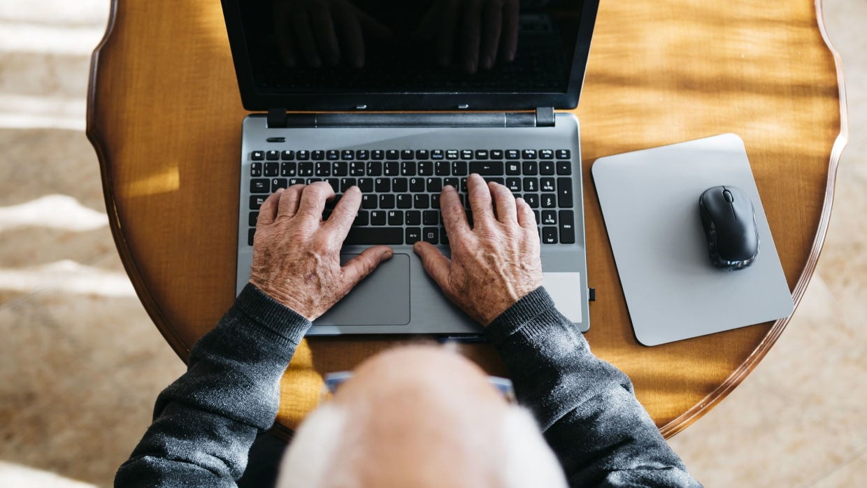 hands typing on laptop overhead