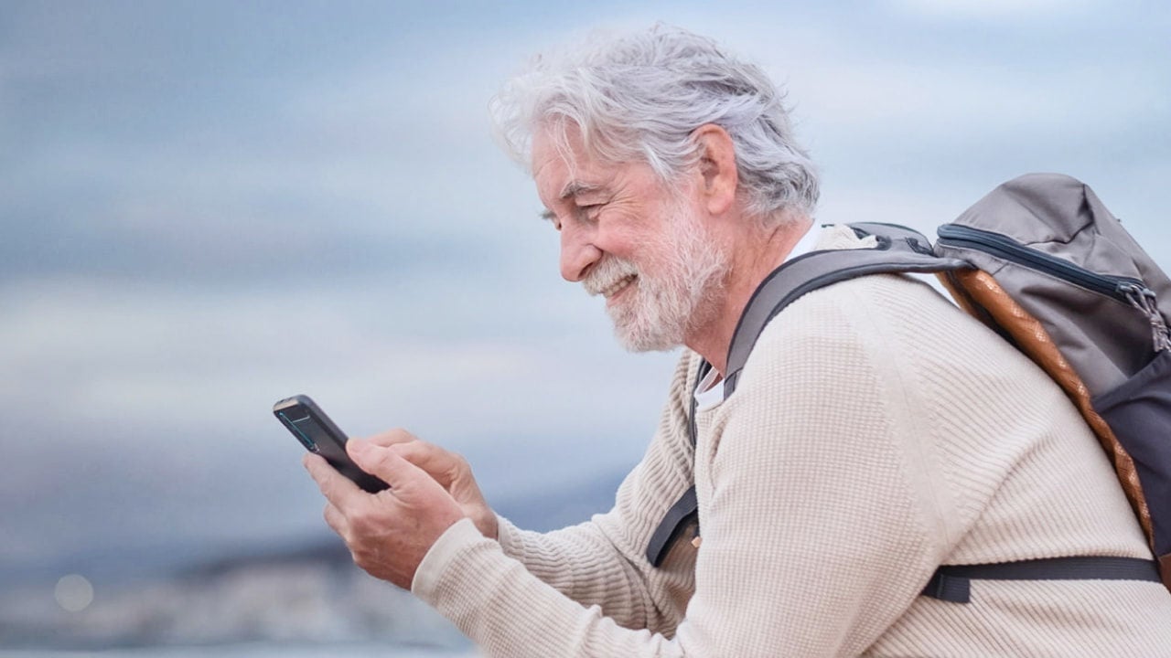 senior man hiking with phone