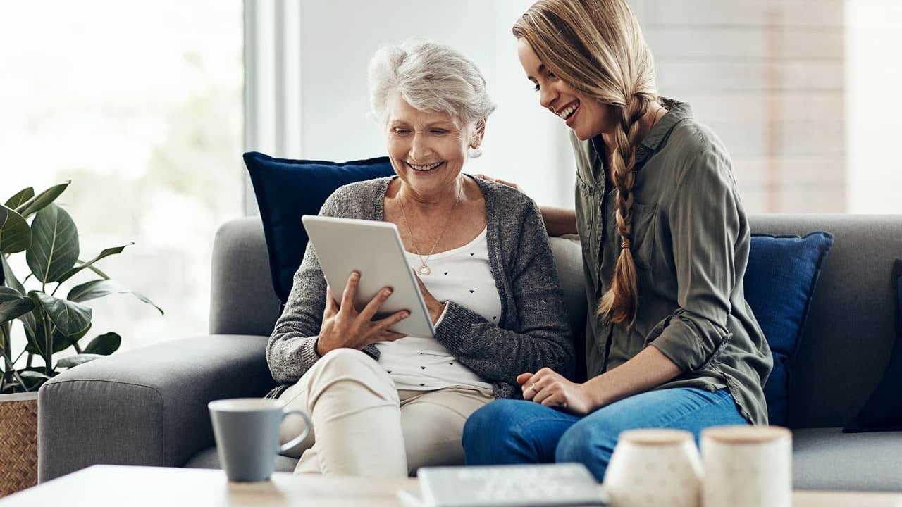 senior woman and daughter with tablet