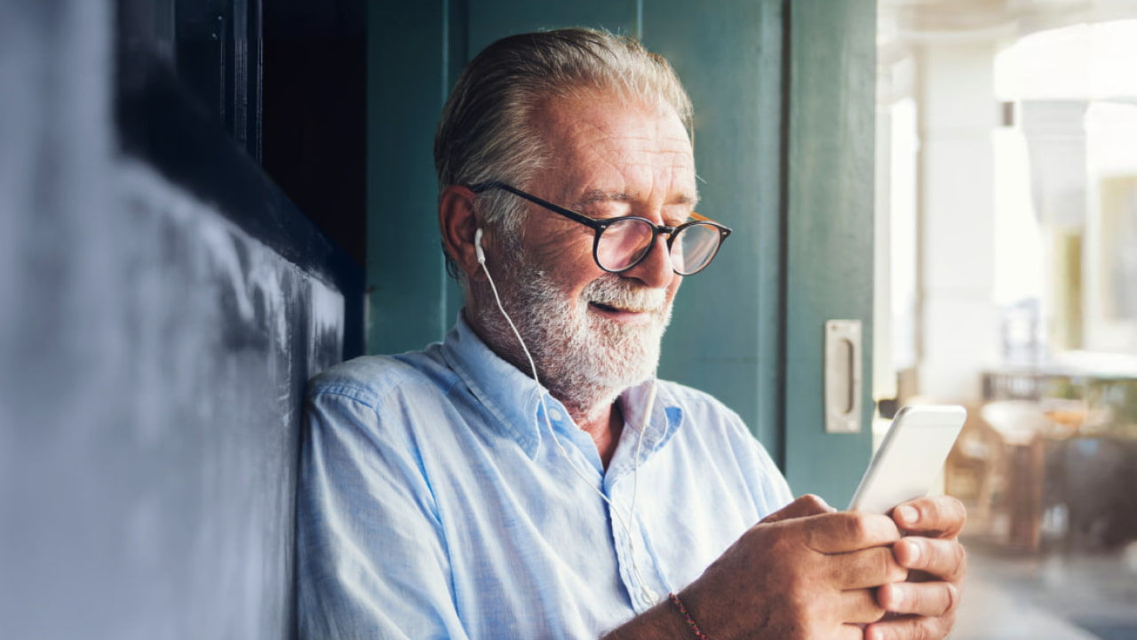 senior man with phone and earphones