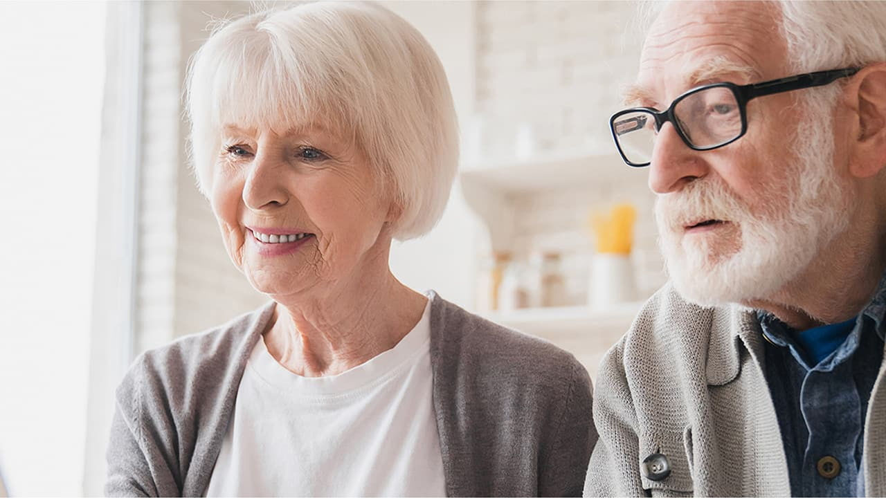 senior couple on laptop paying with card