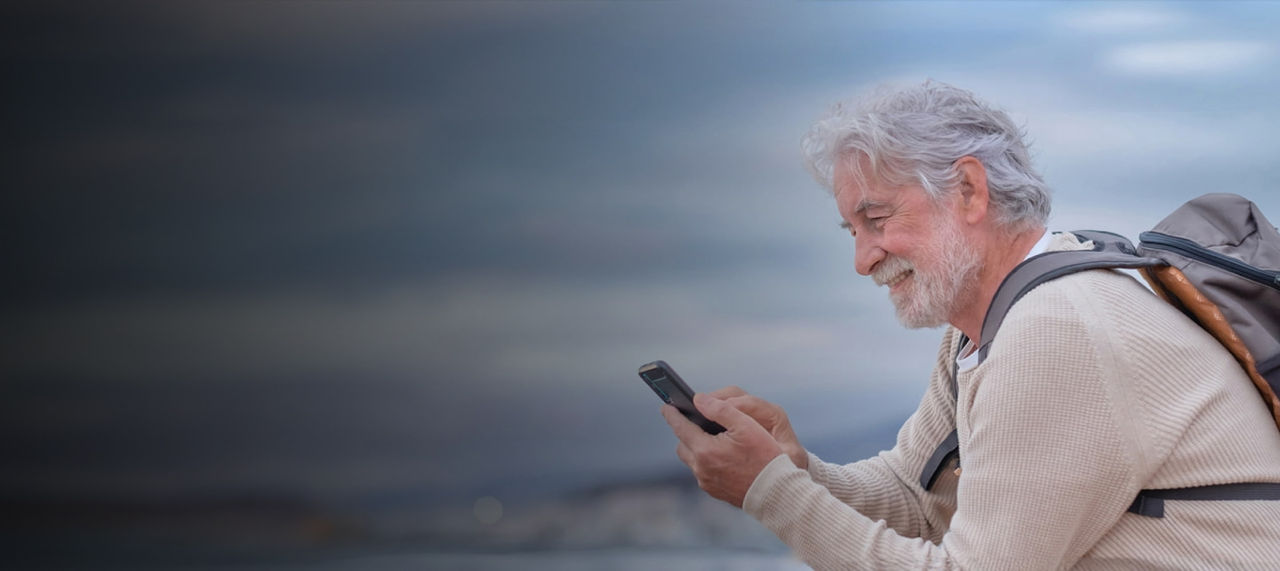 senior man hiking with phone