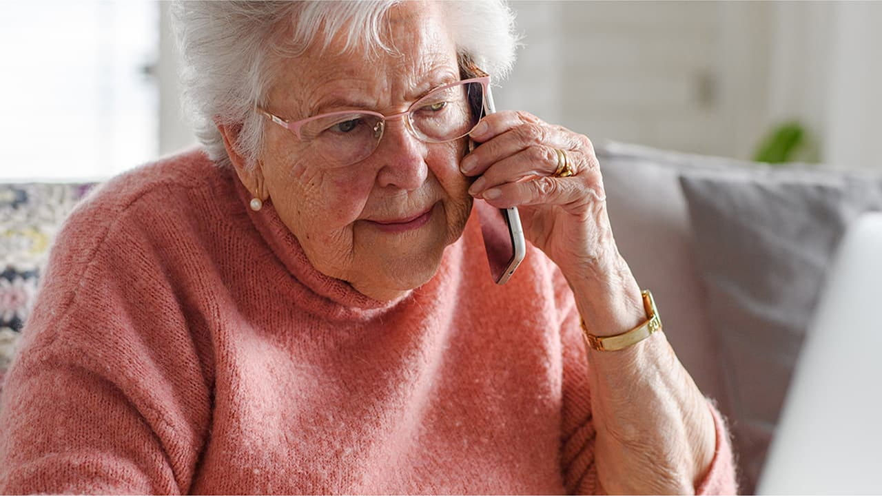 senior woman on phone using laptop