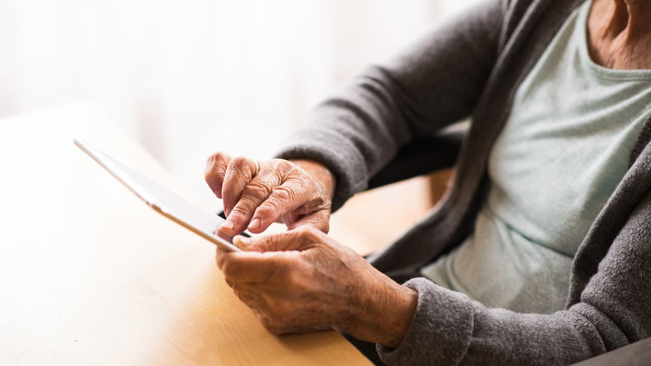 older woman using tablet at the table