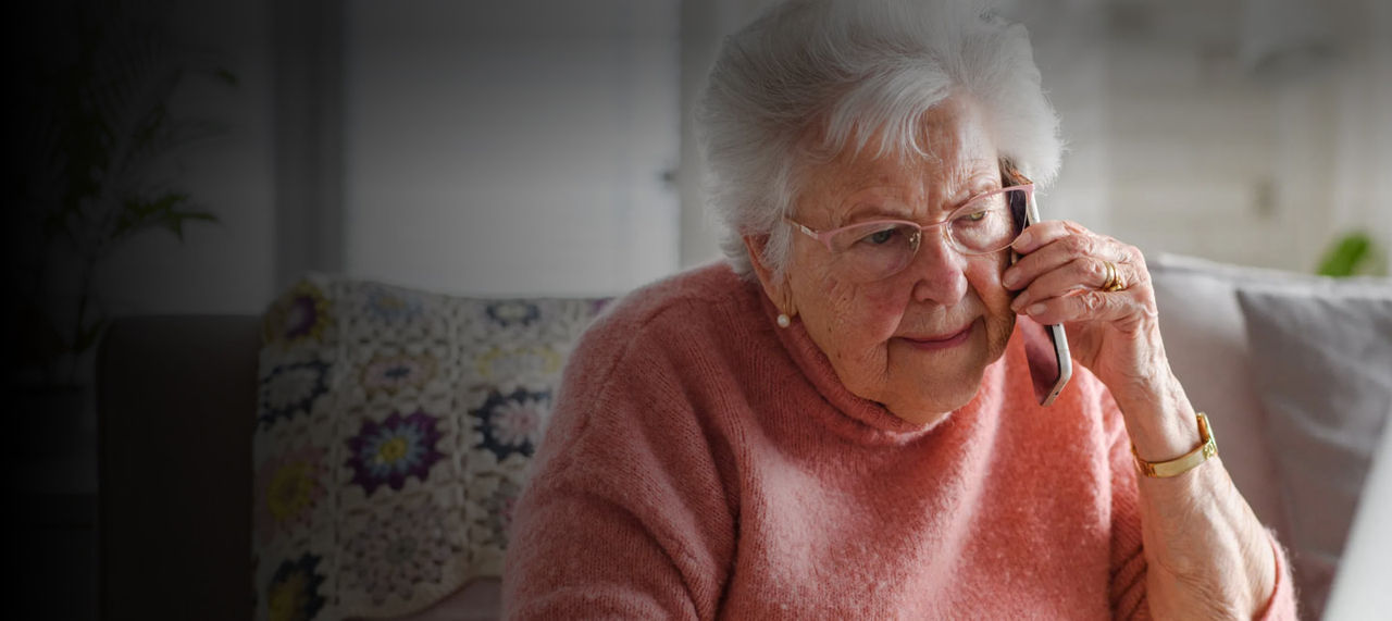 senior woman on phone using laptop