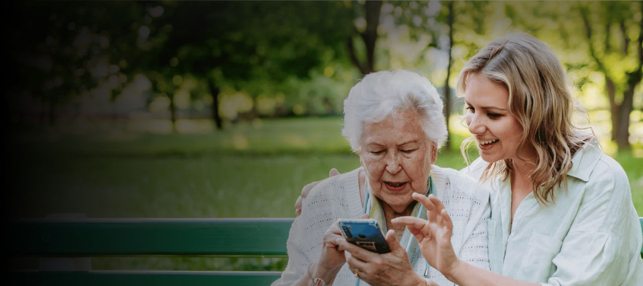 senior woman and daughter with phone in hand