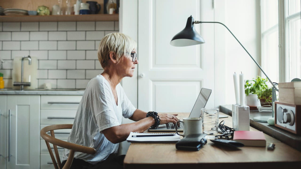 woman working on laptop at kitchen table