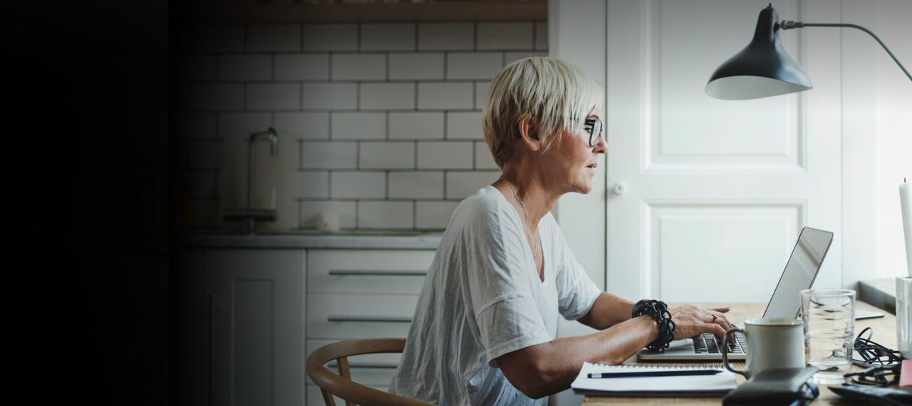 woman working on laptop at kitchen table