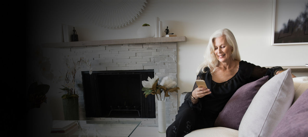 senior woman using phone on sofa